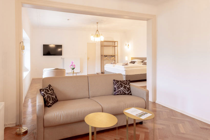 Gemütliches Zimmer mit Sitzecke und Doppelbett in der Villa Schönthaler
