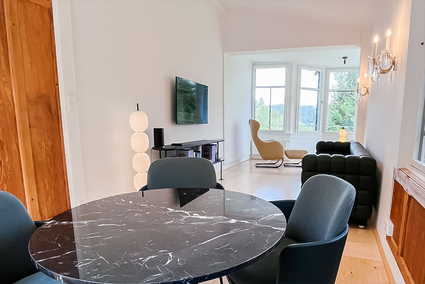 Modern eingerichtetes Wohnzimmer mit einem eleganten Esstisch, gemütlicher Sitzecke