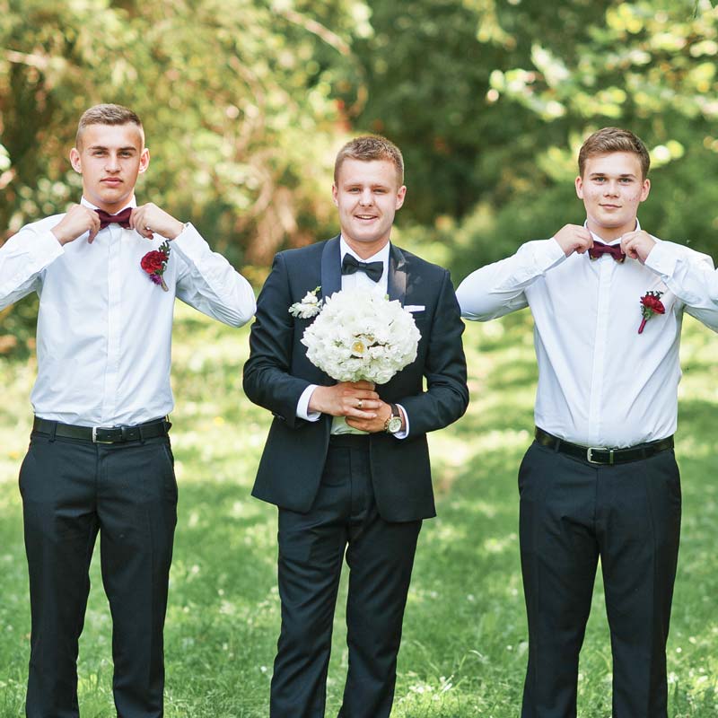 Bräutigam mit Freunden vor der Hochzeit mit Brautstrauss